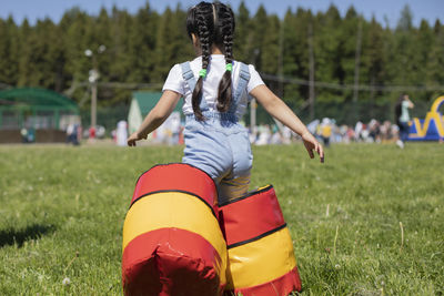 Rear view of woman with umbrella on field