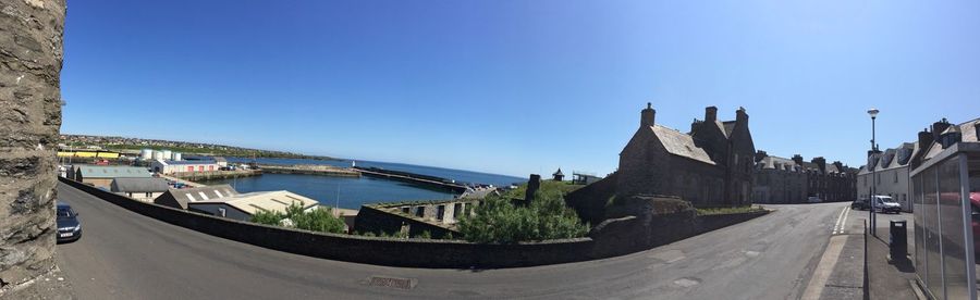 Panoramic view of city against clear blue sky