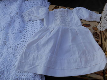 Close-up of white dress on bed