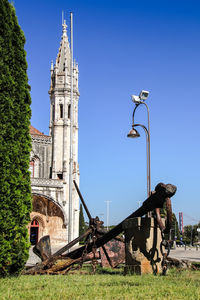 Street light by historic building against clear blue sky