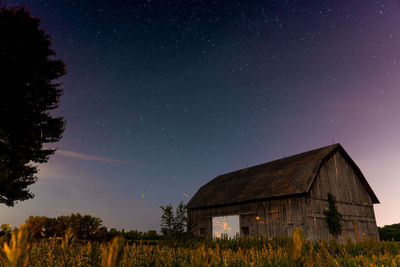 House on field against sky at night