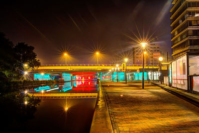 Illuminated bridge over canal in city at night