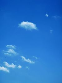 Low angle view of moon in blue sky