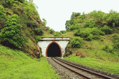 Arch bridge over railroad track against sky