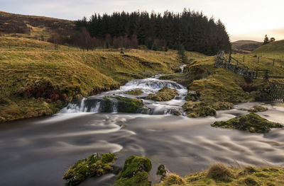 Scenic view of waterfall against sky