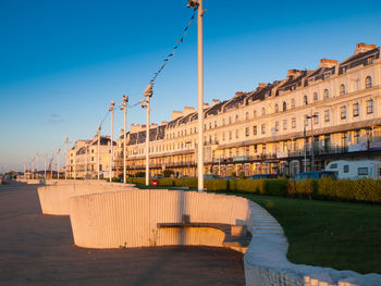 View of canal in city against clear blue sky