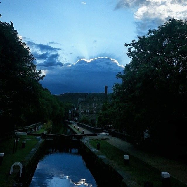 tree, sky, water, built structure, cloud - sky, river, architecture, mountain, nature, cloud, bridge - man made structure, beauty in nature, transportation, reflection, scenics, tranquility, tranquil scene, building exterior, car, day