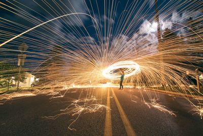 Woman standing in illuminated circle at night