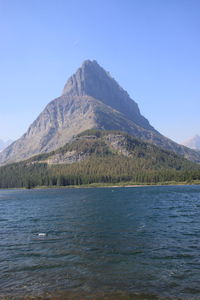 Scenic view of sea and mountains against clear blue sky