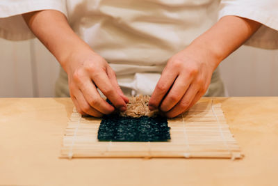 Midsection of man preparing food on table