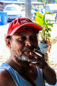 Portrait of man holding camera outdoors