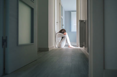 Rear view of woman standing in corridor