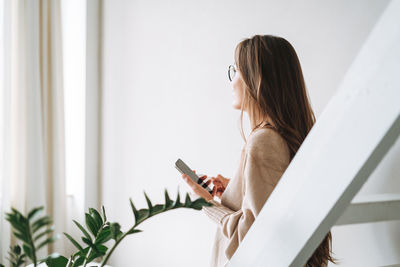 Side view of woman using mobile phone