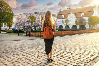 Full length rear view of woman standing against sky