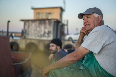 Fishermen sitting in harbour at sunset