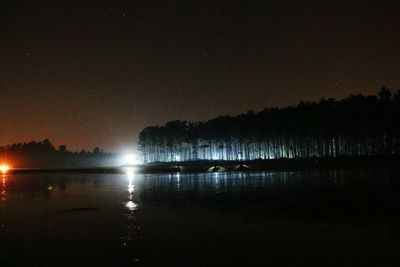 Scenic view of lake against sky at night