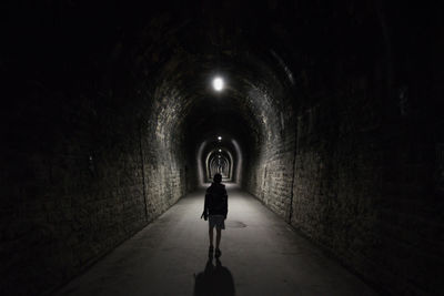 Rear view of man standing in tunnel