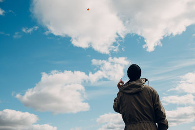 Rear view of man standing against sky