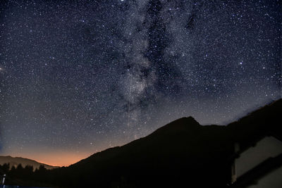 Low angle view of silhouette mountain against sky at night