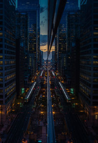 High angle view of illuminated street amidst buildings in city at night