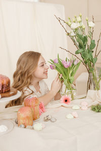 Cute girl smelling flowers at home