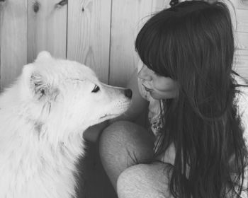 Young woman puckering lips while looking at dog outdoors