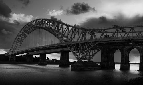 View of bridge over river against cloudy sky