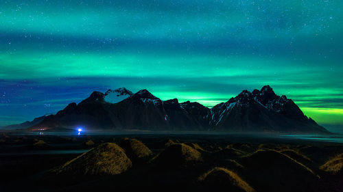 Scenic view of snowcapped mountains against sky at night