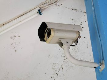 Low angle view of telephone pole against white wall