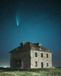 Old building on field against sky at night