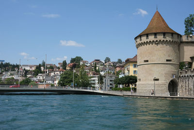 Buildings by swimming pool in city against sky
