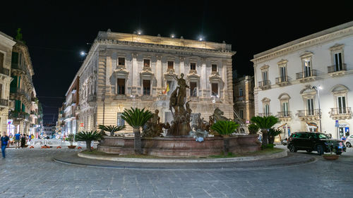 Statue in city at night