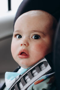 Sweet little baby boy in the car in baby safety seat