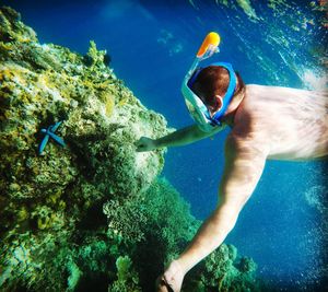 Shirtless young man swimming in sea