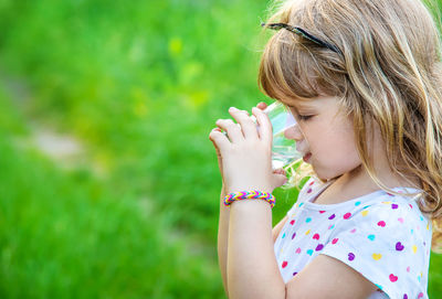 Side view of girl drinking water from glass