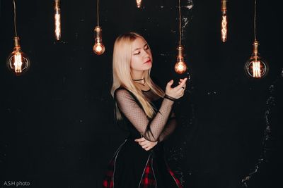 Reflection of woman on illuminated light bulb