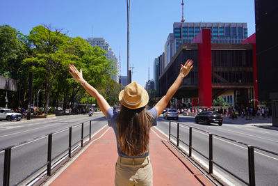 Rear view of woman standing by railing