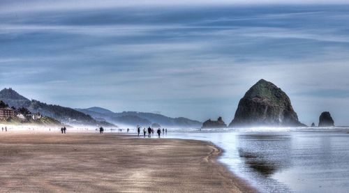 Scenic view of beach against cloudy sky