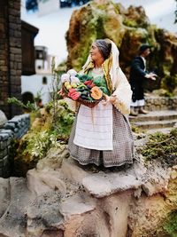 Midsection of woman holding basket while standing outdoors