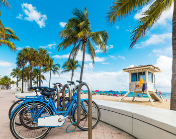 Bicycles on beach against blue sky