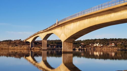 Arch bridge over river against clear sky