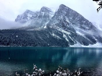 Scenic view of lake and snowcapped mountains against sky