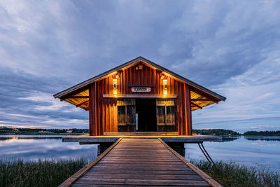 Pier amidst lake against sky at dusk