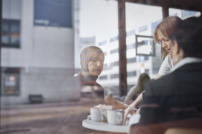 View through window of women in cafe