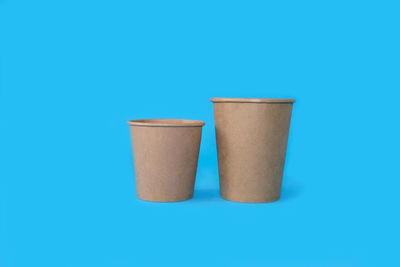 Close-up of disposable cup against blue background