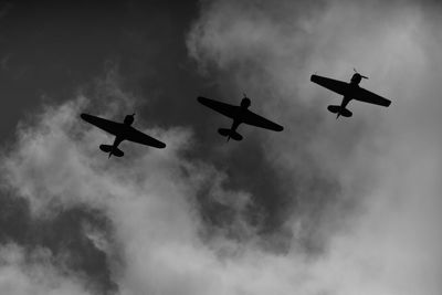 Low angle view of silhouette airplane against sky