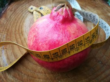 High angle view of pomegranate with tape measure on table