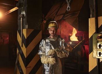 Portrait of confident worker wearing protective workwear standing in foundry