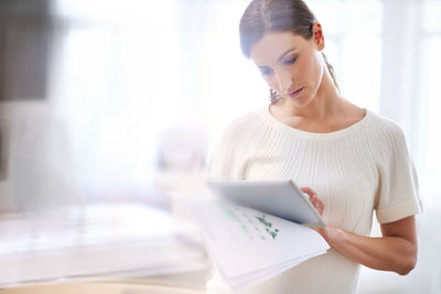 Woman using digital tablet in office