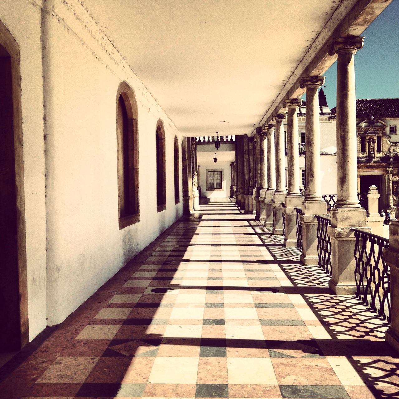 architecture, built structure, the way forward, diminishing perspective, corridor, indoors, building exterior, narrow, building, in a row, vanishing point, empty, alley, walkway, long, architectural column, flooring, tiled floor, colonnade, day